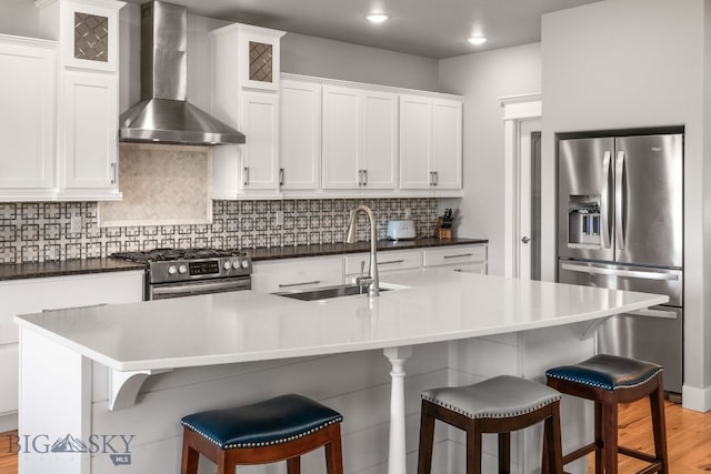 85 Riparian Way, Bozeman, MT 59718 - kitchen with wall chimney range hood, appliances with stainless steel finishes, light wood-style floors, tasteful backsplash, and white cabinetry