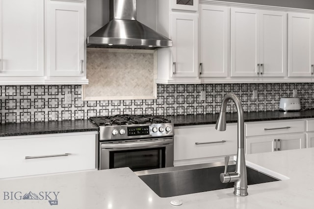 85 Riparian Way, Bozeman, MT 59718 - kitchen with wall chimney exhaust hood, stainless steel gas range oven, white cabinetry, and decorative backsplash