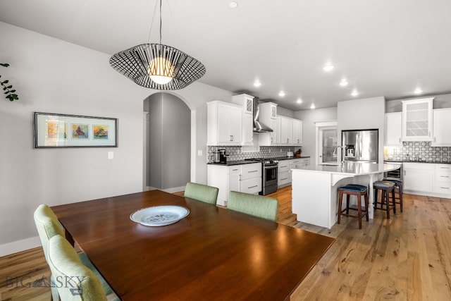 85 Riparian Way, Bozeman, MT 59718 - dining space with light wood-style floors, arched walkways, and recessed lighting