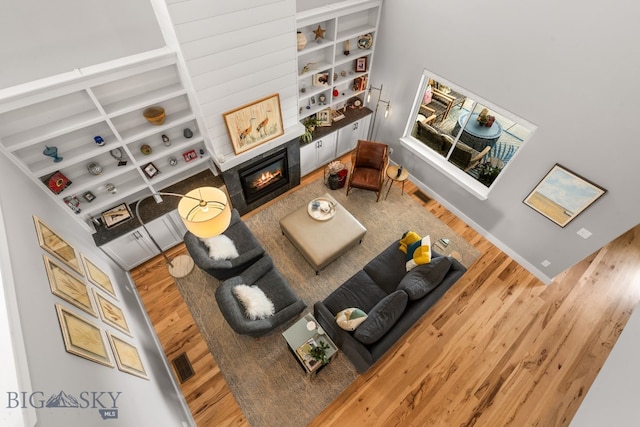 85 Riparian Way, Bozeman, MT 59718 - living area featuring wood finished floors, a glass covered fireplace, and built in features