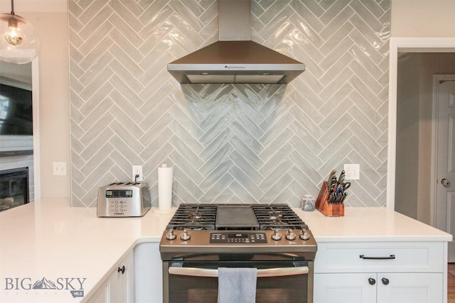 717 N Aster Ave, Bozeman, MT 59718 - kitchen with wall chimney range hood, stainless steel range with gas stovetop, backsplash, white cabinetry, and light countertops