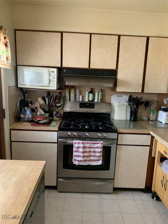 2320 S S Dr, Butte, MT 59701 - kitchen with stainless steel range with gas cooktop, white microwave, under cabinet range hood, light countertops, and light tile patterned flooring
