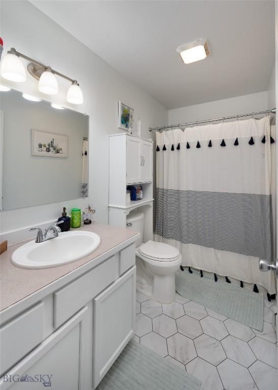 208 Show Pl Unit A, Belgrade, MT 59714 - bathroom with vanity, tile patterned floors, and curtained shower