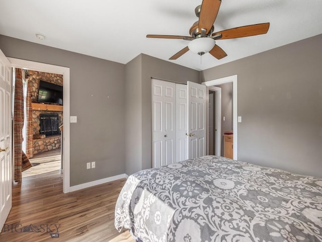 417 Firelight, Big Sky, MT 59716 - bedroom with wood finished floors, a closet, a fireplace, and a ceiling fan