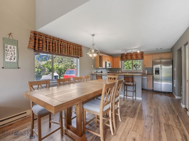 417 Firelight, Big Sky, MT 59716 - dining area featuring a baseboard heating unit, light wood finished floors, and rail lighting