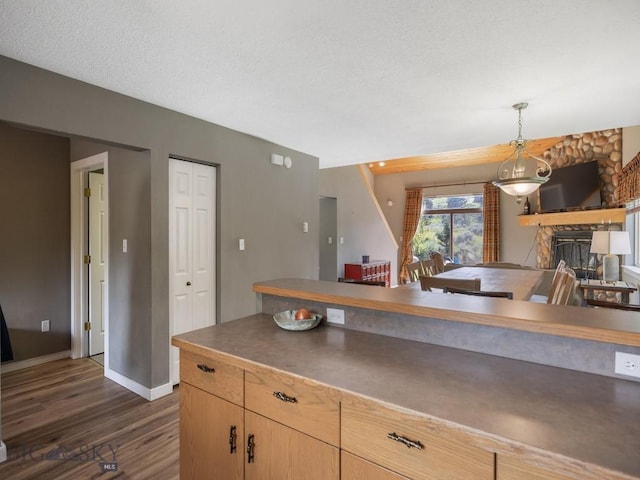 417 Firelight, Big Sky, MT 59716 - kitchen with dark wood-style floors, hanging light fixtures, light brown cabinetry, and dark countertops