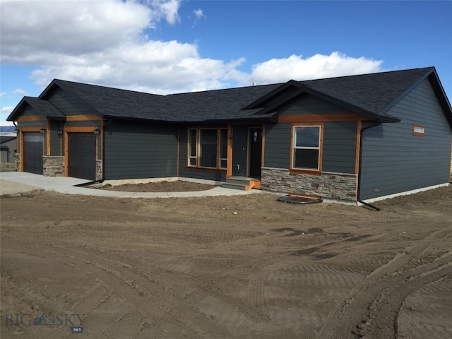 639 Avon Cir, Butte, MT 59701 - view of front of home featuring stone siding, an attached garage, and a shingled roof