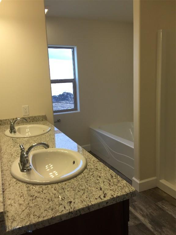 639 Avon Cir, Butte, MT 59701 - full bath with double vanity, wood finished floors, a bath, and a shower