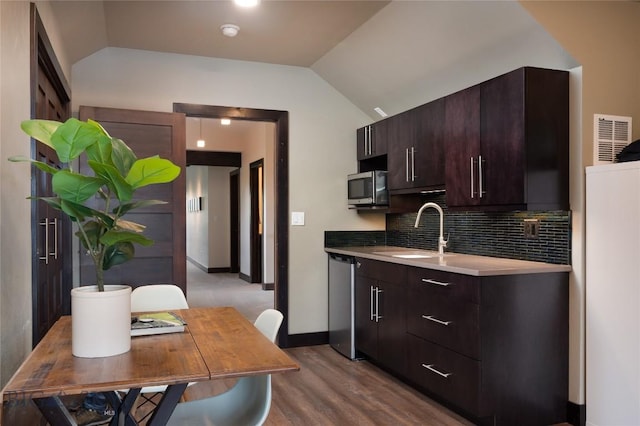 89 W Fieldview St, Bozeman, MT 59715 - kitchen with stainless steel appliances, vaulted ceiling, dark brown cabinetry, decorative backsplash, and dark wood finished floors