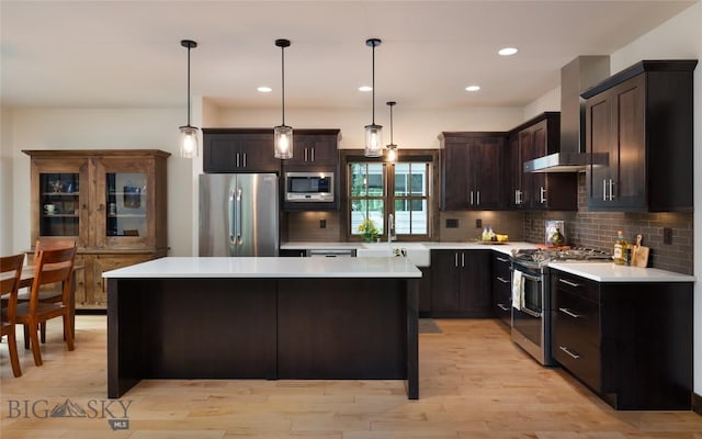 89 W Fieldview St, Bozeman, MT 59715 - kitchen featuring stainless steel appliances, wall chimney range hood, light countertops, backsplash, and a kitchen island