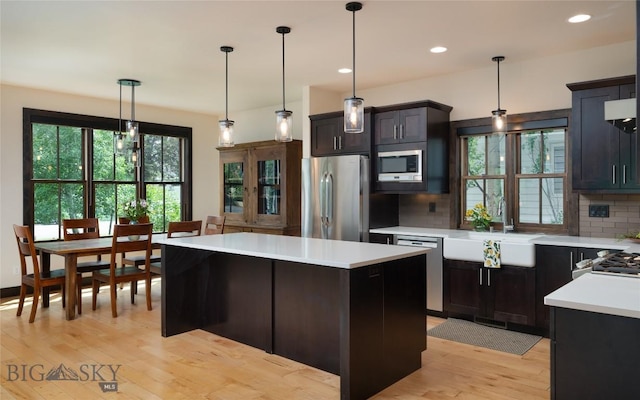 89 W Fieldview St, Bozeman, MT 59715 - kitchen with stainless steel appliances, light countertops, light wood-style flooring, decorative backsplash, and a center island