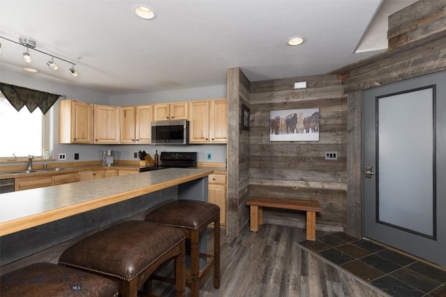15 Spotted Fawn Ct, Big Sky, MT 59716 - kitchen with stainless steel microwave, light brown cabinets, stove, wooden walls, and dark wood-style flooring