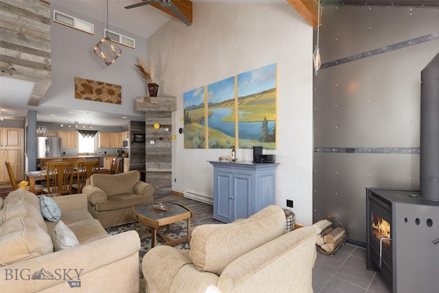 15 Spotted Fawn Ct, Big Sky, MT 59716 - living area with a wood stove, baseboard heating, a ceiling fan, high vaulted ceiling, and beam ceiling