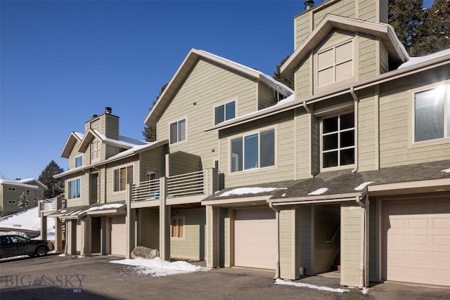15 Spotted Fawn Ct, Big Sky, MT 59716 - view of front of property featuring a chimney, an attached garage, and a balcony