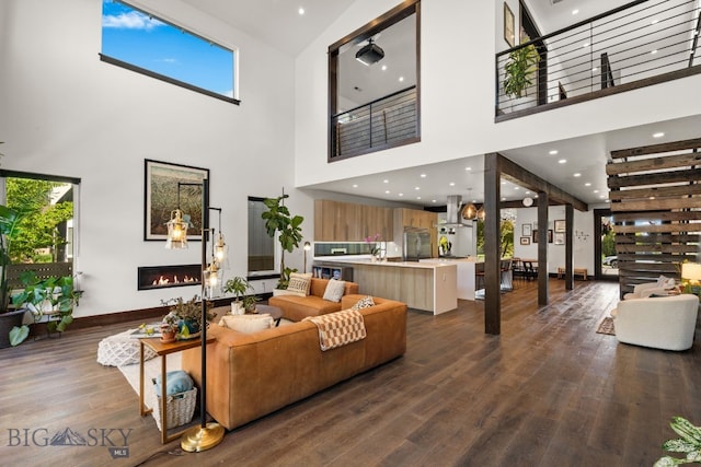 4412 Bembrick St, Bozeman, MT 59718 - living area with a towering ceiling, a glass covered fireplace, dark wood-type flooring, and healthy amount of natural light