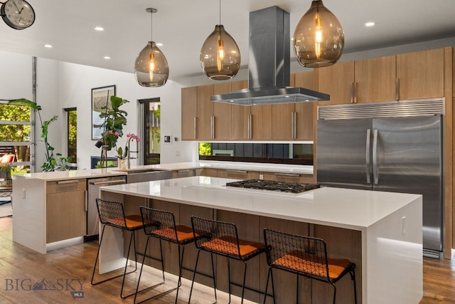 4412 Bembrick St, Bozeman, MT 59718 - kitchen with island range hood, appliances with stainless steel finishes, a peninsula, dark wood-style floors, and a kitchen island