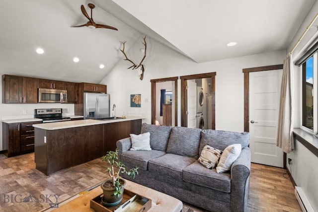 4412 Bembrick St, Bozeman, MT 59718 - living area with stacked washer / dryer, a baseboard heating unit, light wood-type flooring, recessed lighting, and lofted ceiling