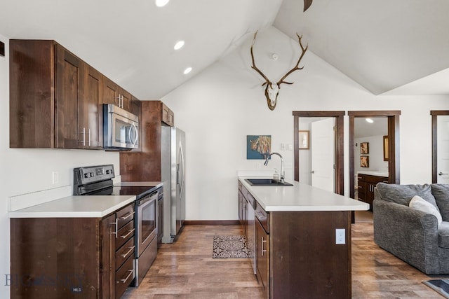 4412 Bembrick St, Bozeman, MT 59718 - kitchen featuring appliances with stainless steel finishes, wood finished floors, open floor plan, dark brown cabinetry, and recessed lighting