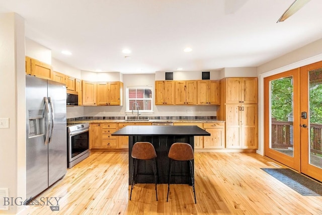 4619 Cascade St, Bozeman, MT 59718 - kitchen with appliances with stainless steel finishes, light wood finished floors, a breakfast bar, a kitchen island, and recessed lighting