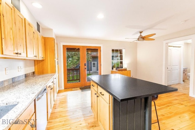 4619 Cascade St, Bozeman, MT 59718 - kitchen with light wood-style flooring, stainless steel dishwasher, a breakfast bar area, a ceiling fan, and light brown cabinetry