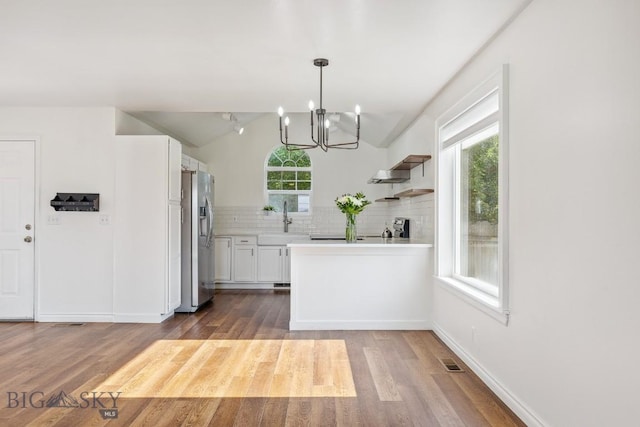 3601 Ravalli St, Bozeman, MT 59718 - kitchen with stainless steel fridge, a chandelier, light countertops, wood finished floors, and vaulted ceiling