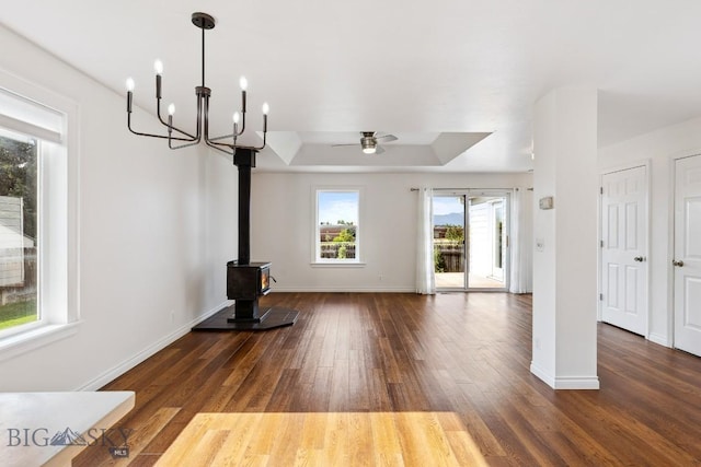 3601 Ravalli St, Bozeman, MT 59718 - unfurnished living room with a ceiling fan, wood finished floors, a wood stove, a raised ceiling, and a chandelier