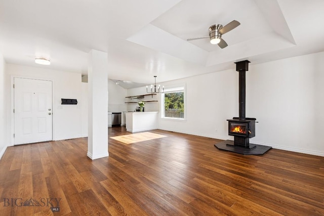 3601 Ravalli St, Bozeman, MT 59718 - unfurnished living room with dark wood-style flooring, ceiling fan, a tray ceiling, a wood stove, and a chandelier