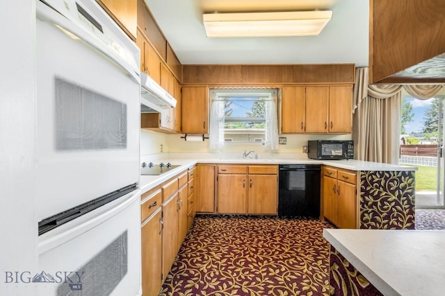 1721 S Willson Ave, Bozeman, MT 59715 - kitchen with black appliances, light countertops, ventilation hood, and brown cabinets