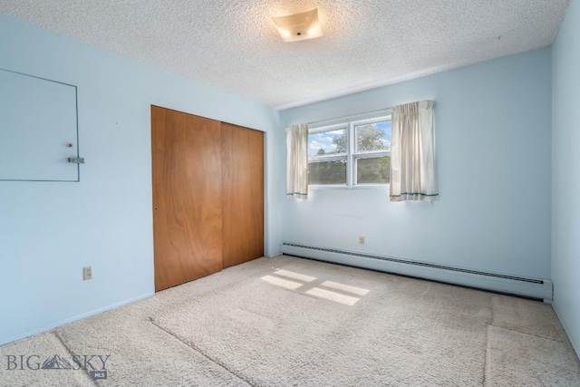 1721 S Willson Ave, Bozeman, MT 59715 - unfurnished bedroom featuring a baseboard radiator, a closet, carpet, and a textured ceiling