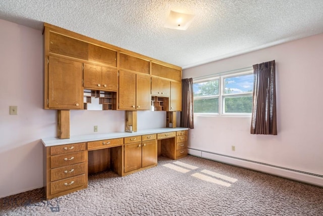 1721 S Willson Ave, Bozeman, MT 59715 - kitchen featuring baseboard heating, a textured ceiling, light carpet, light countertops, and brown cabinets