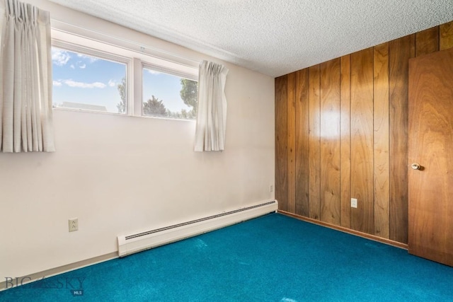 1721 S Willson Ave, Bozeman, MT 59715 - carpeted spare room featuring a baseboard heating unit, wood walls, and a textured ceiling