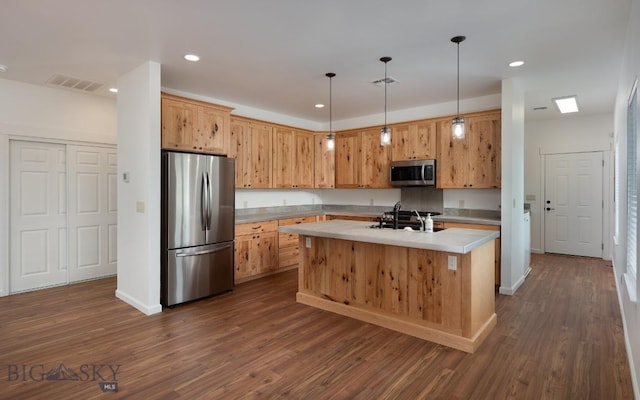 375 Price Rd, Three Forks, MT 59752 - kitchen featuring stainless steel appliances, light countertops, an island with sink, dark wood-style flooring, and pendant lighting