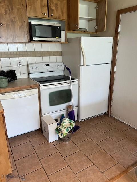 21 Sitting Bull Rd Unit 1233, Big Sky, MT 59716 - kitchen with white appliances, open shelves, tasteful backsplash, and light tile patterned floors