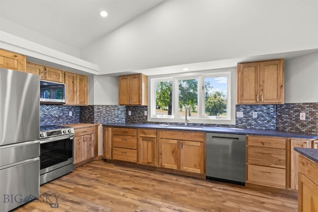 4901 Itana Cir, Bozeman, MT 59715 - kitchen featuring stainless steel appliances, dark countertops, backsplash, light wood-style flooring, and recessed lighting
