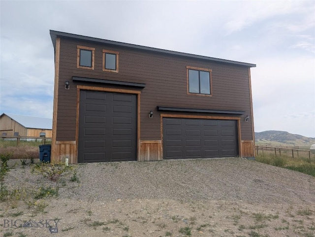 51 Highlander Dr, Three Forks, MT 59752 - garage with gravel driveway and a mountain view