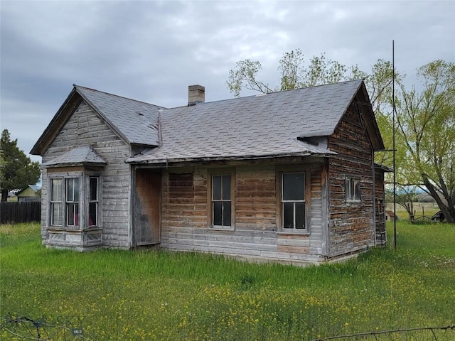 60 E Old Town Main St, Three Forks, MT 59752 - rear view of property featuring roof with shingles, a yard, and a chimney