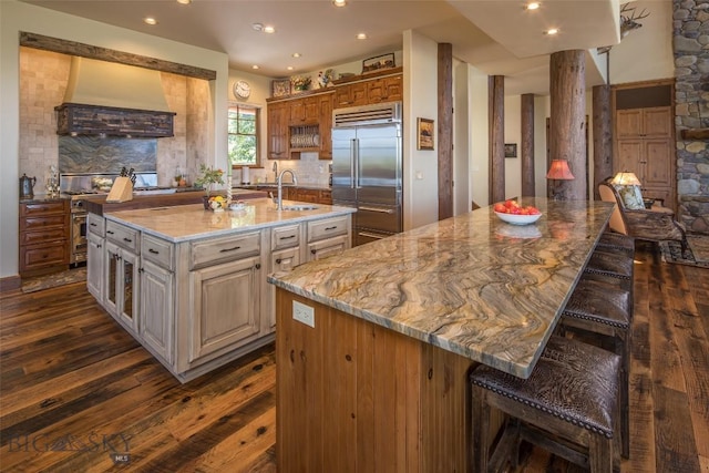 390 Hayrake Ln, Bozeman, MT 59715 - kitchen with built in refrigerator, premium range hood, a spacious island, dark wood-style floors, and a breakfast bar area