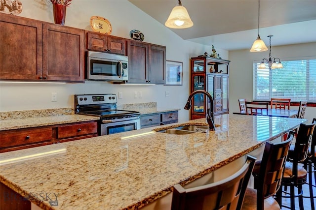 9848 Durston Rd Unit A, Bozeman, MT 59718 - kitchen with appliances with stainless steel finishes, a breakfast bar area, decorative light fixtures, and light stone counters