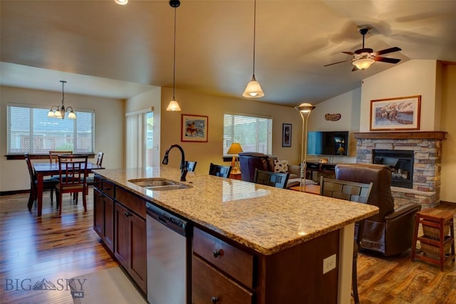 9848 Durston Rd Unit A, Bozeman, MT 59718 - kitchen with stainless steel dishwasher, wood finished floors, a fireplace, a kitchen island with sink, and vaulted ceiling