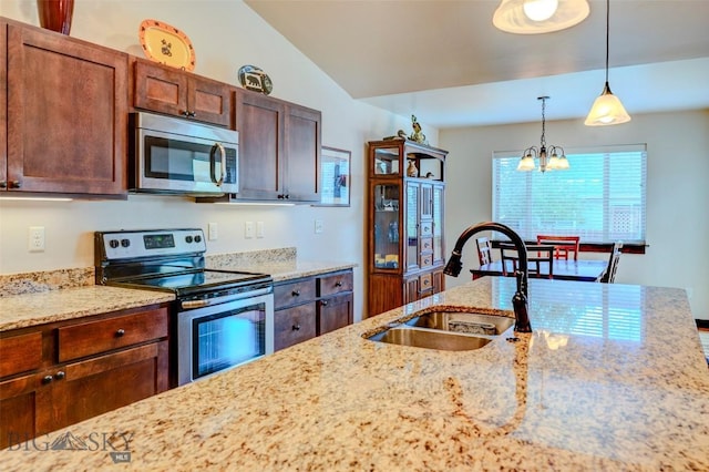 9848 Durston Rd Unit A, Bozeman, MT 59718 - kitchen with appliances with stainless steel finishes, pendant lighting, light stone counters, a chandelier, and vaulted ceiling