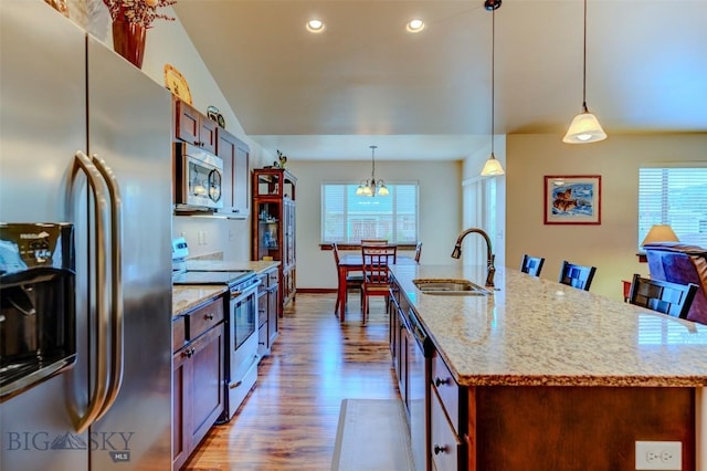 9848 Durston Rd Unit A, Bozeman, MT 59718 - kitchen with stainless steel appliances, wood finished floors, light stone counters, pendant lighting, and an island with sink