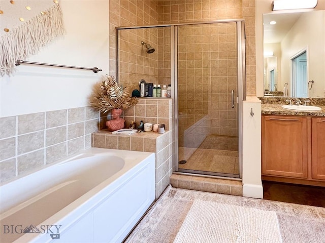 140 Village Crossing Way Unit 1J, Bozeman, MT 59715 - full bathroom featuring vanity, a bath, and a stall shower