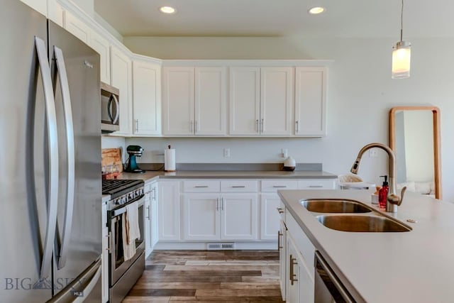 2002 Chipset St Unit A, Bozeman, MT 59718 - kitchen featuring appliances with stainless steel finishes, recessed lighting, white cabinets, pendant lighting, and wood finished floors