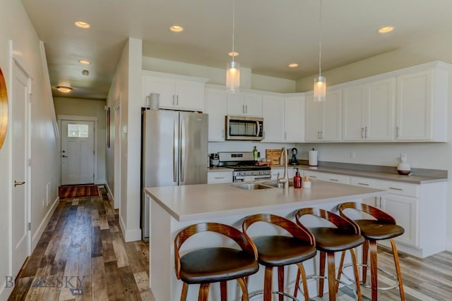 2002 Chipset St Unit A, Bozeman, MT 59718 - kitchen featuring appliances with stainless steel finishes, white cabinets, wood finished floors, and recessed lighting
