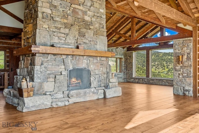 94 Sky Band Trl, Livingston, MT 59047 - unfurnished living room with hardwood / wood-style flooring, an outdoor stone fireplace, a wood ceiling with exposed beams, and high vaulted ceiling