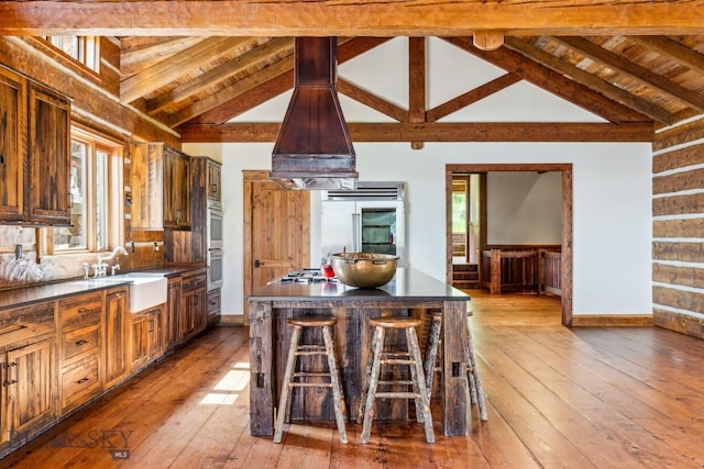94 Sky Band Trl, Livingston, MT 59047 - kitchen with a kitchen bar, stainless steel appliances, wood-type flooring, wooden ceiling, and dark countertops