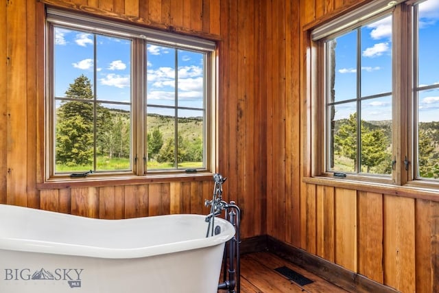 94 Sky Band Trl, Livingston, MT 59047 - bathroom with a freestanding tub, wood walls, healthy amount of natural light, and wood finished floors
