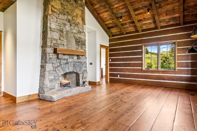 94 Sky Band Trl, Livingston, MT 59047 - unfurnished living room featuring wooden ceiling, hardwood / wood-style flooring, wood walls, and a stone fireplace