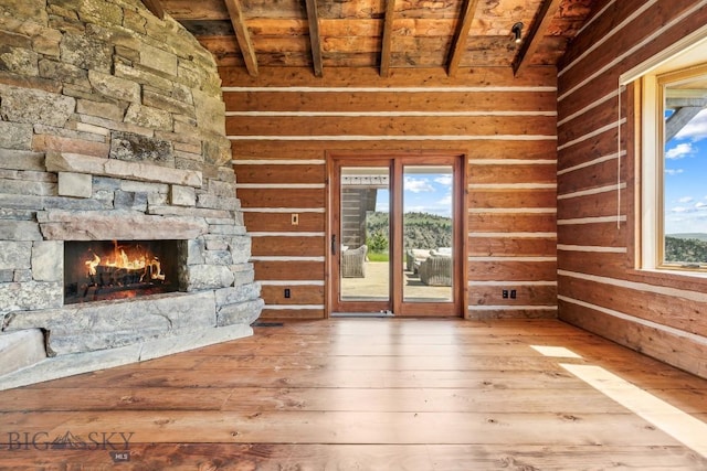 94 Sky Band Trl, Livingston, MT 59047 - unfurnished living room featuring wood-type flooring, wooden ceiling, and a stone fireplace