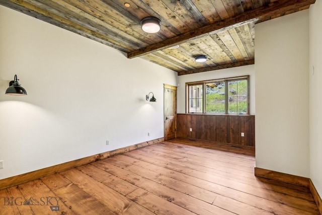 94 Sky Band Trl, Livingston, MT 59047 - unfurnished room with hardwood / wood-style floors, a wood ceiling with exposed beams, a wainscoted wall, and wood walls
